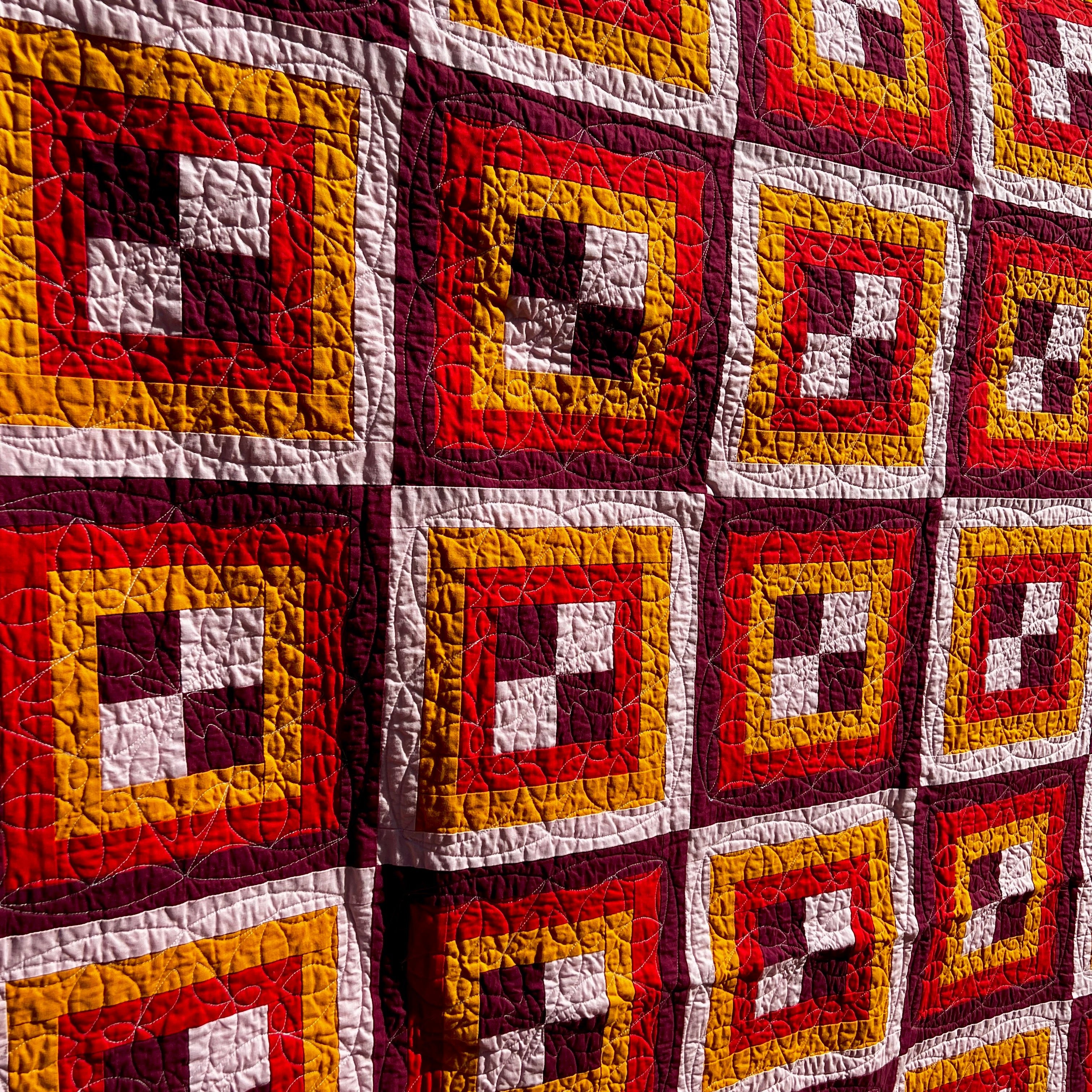 rec room - block pattern handmade quilt - red, pink, white, orange - closeup
